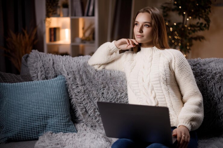 Mujer soñadora usando laptop