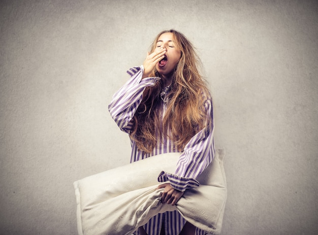 Mujer soñolienta con una almohada