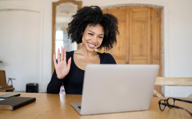 Una mujer sonríe, el chat de comunicación por video funciona, la pantalla de comunicación en línea mira a la cámara