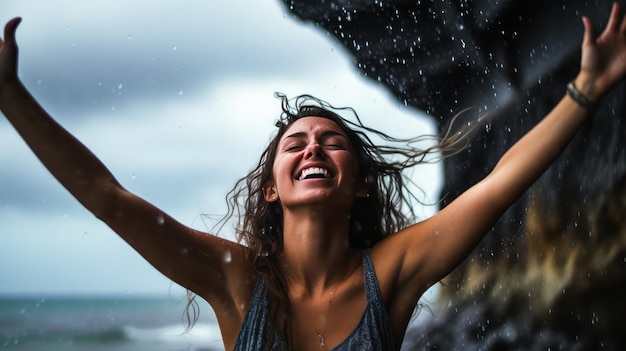 Una mujer sonríe bajo la lluvia con las manos en alto.