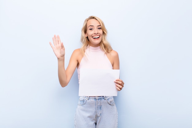 Mujer sonriendo alegre y alegremente, saludando con la mano, dándote la bienvenida y saludándote, o diciéndote adiós