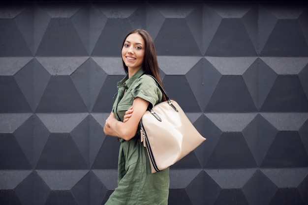 Mujer sonriendo con un bolso en el hombro