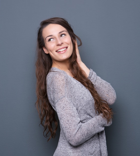 Mujer sonriendo con la mano en el cabello