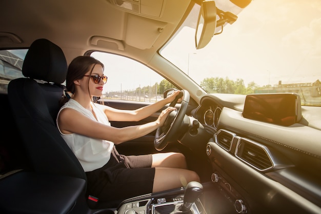 Mujer sonriendo mientras conduce un auto