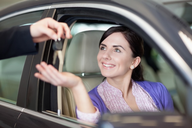 Mujer sonriendo mientras está sentado en un coche