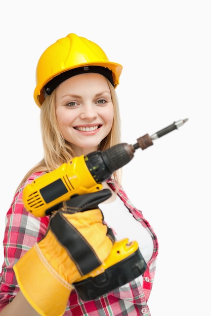 Mujer sonriendo mientras sostiene un destornillador eléctrico