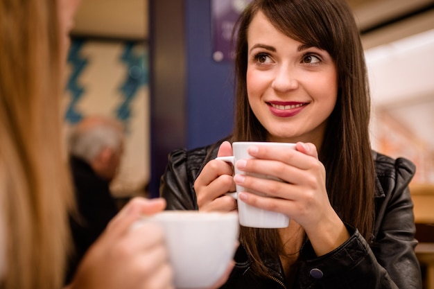 Mujer sonriendo mientras toma un café