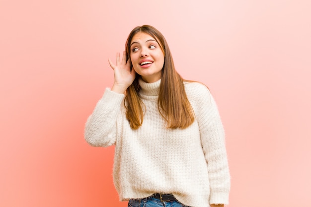 mujer sonriendo, mirando curiosamente a un lado, tratando de escuchar chismes o escuchando un secreto