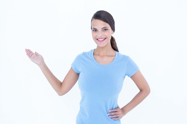 Mujer sonriendo presentando algo con su mano