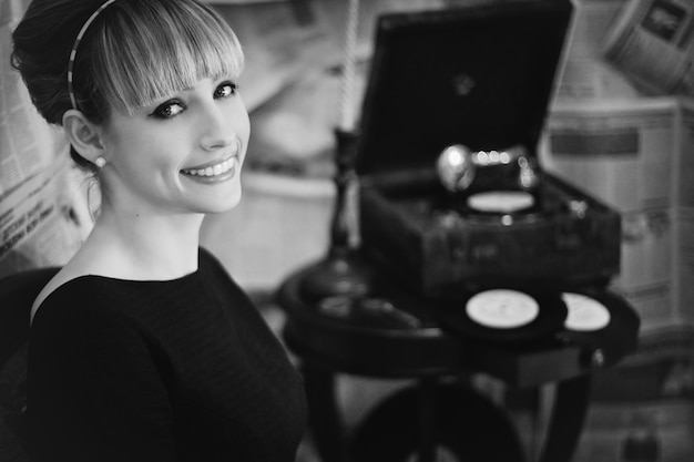 Mujer sonriendo con un tocadiscos de fondo