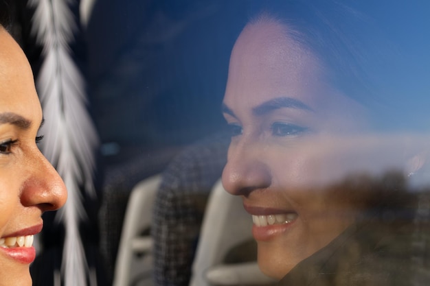 Mujer sonriendo por la ventana del autobús