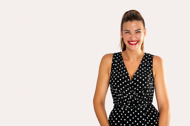 Mujer sonriendo con un vestido negro con puntos blancos