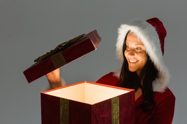 Foto mujer sonriente abriendo regalo de navidad