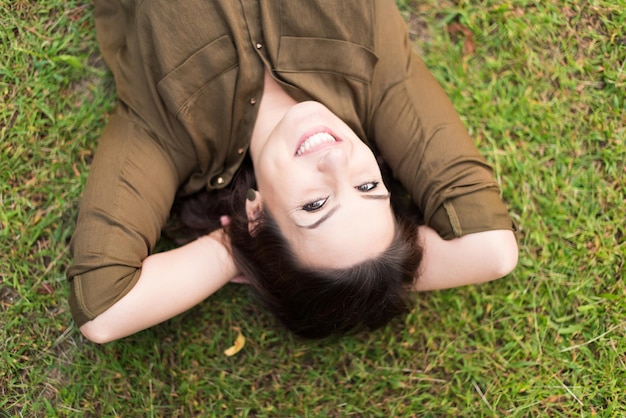 mujer sonriente, acostado, y, relajante, en, pasto o césped