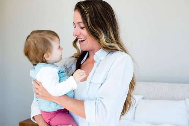 mujer sonriente con un adorable bebé en una habitación