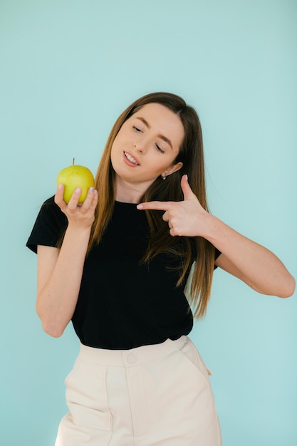Mujer sonriente alegre sosteniendo manzana
