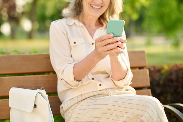 Mujer sonriente con alegría con smartphone en manos