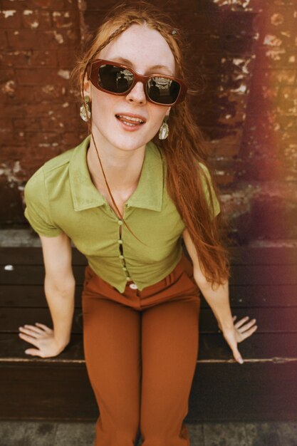 Foto mujer sonriente de alto ángulo con gafas de sol