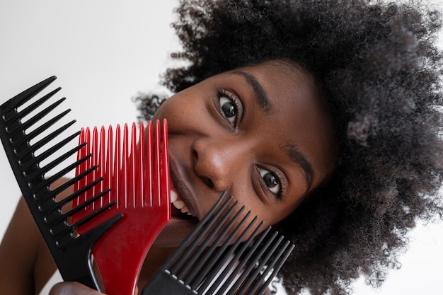 Foto mujer sonriente de alto ángulo usando peines para el cabello