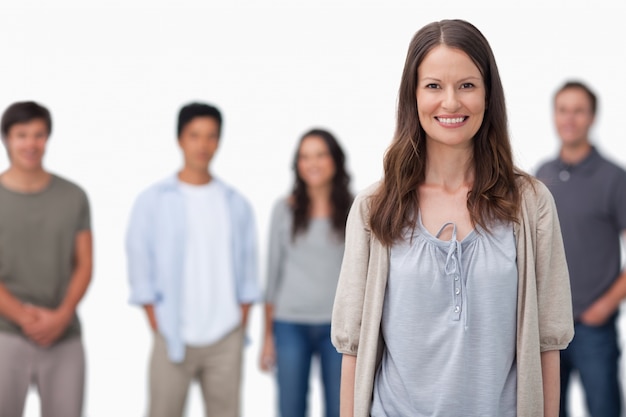 Mujer sonriente con amigos de pie detrás de ella