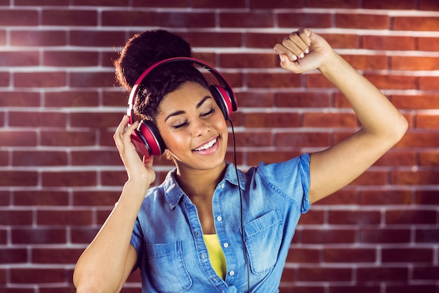 Una mujer sonriente bailando con auriculares