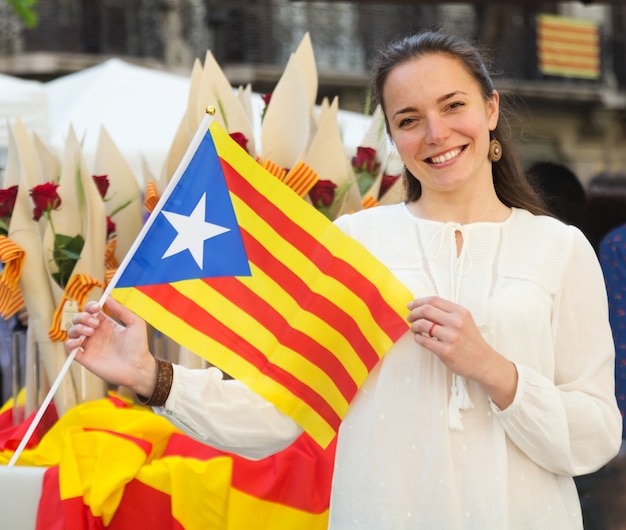 Foto mujer sonriente con la bandera catalana en