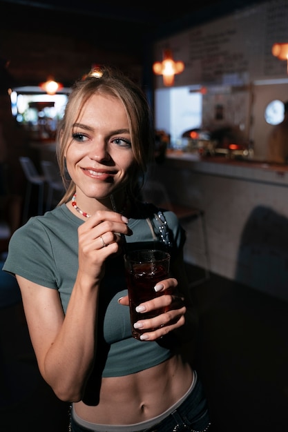 Mujer sonriente con bebida tiro medio