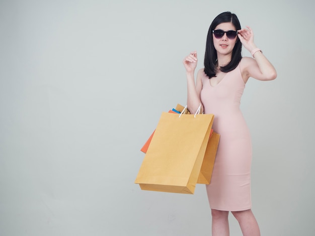 Mujer sonriente de la belleza que sostiene bolsos de compras coloridos