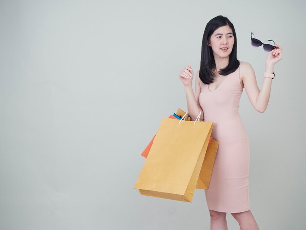 Mujer sonriente de la belleza que sostiene bolsos de compras coloridos