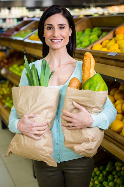 Mujer sonriente con bolsa de supermercado