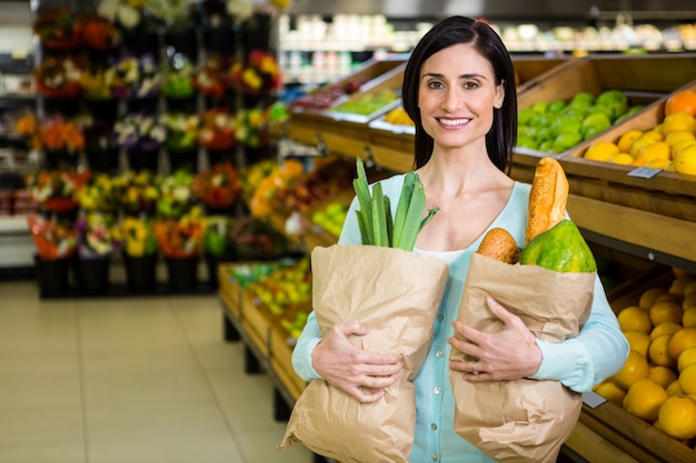 Mujer sonriente con bolsa de supermercado