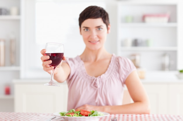 Mujer sonriente brindando con vino