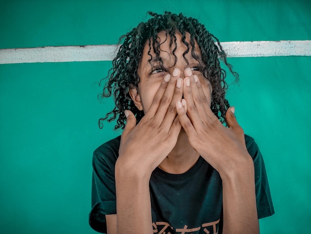 Foto mujer sonriente con el cabello rizado contra la pared