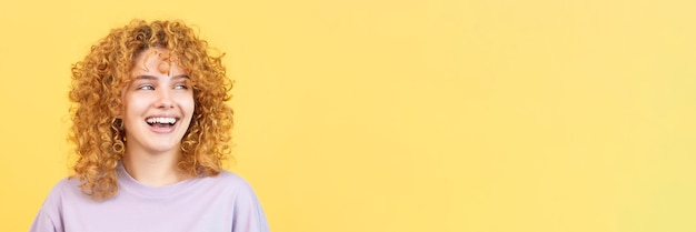 Mujer sonriente con cabello rizado mirando a un lado