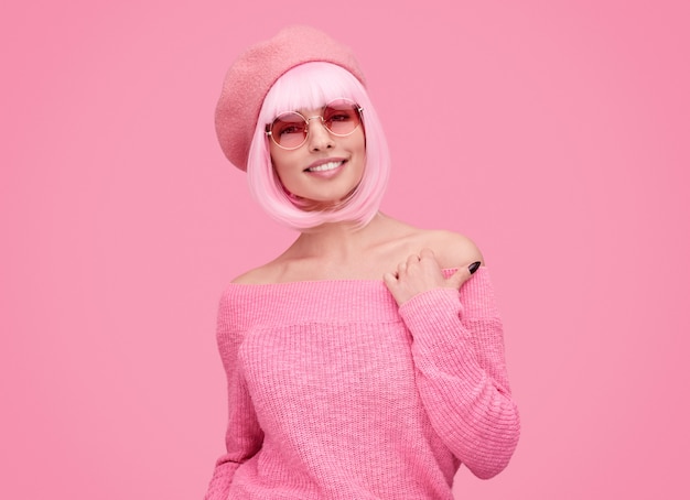 Mujer sonriente con cabello rosado mirando a la cámara