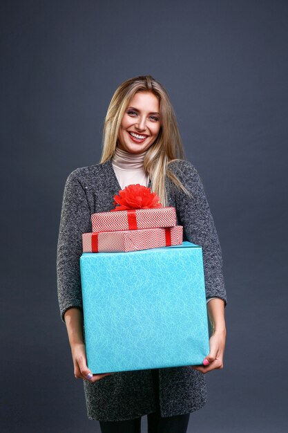 mujer sonriente con cajas de regalo