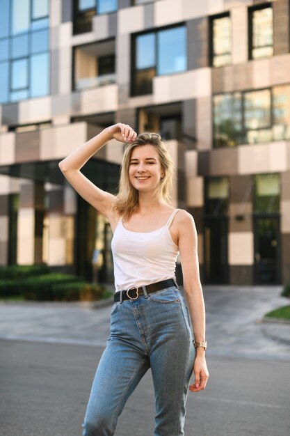 Mujer sonriente en una camiseta blanca y jeans