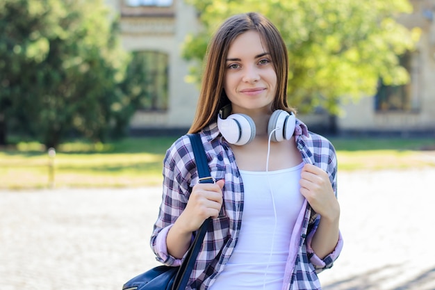 Mujer sonriente con campus mochila y auriculares
