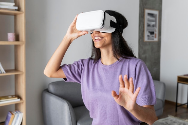 Foto mujer sonriente con casco de realidad virtual en casa