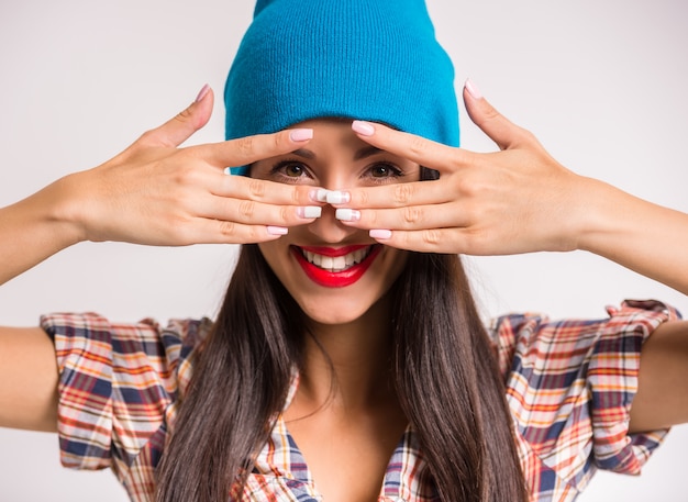 La mujer sonriente en casquillo azul está presentando