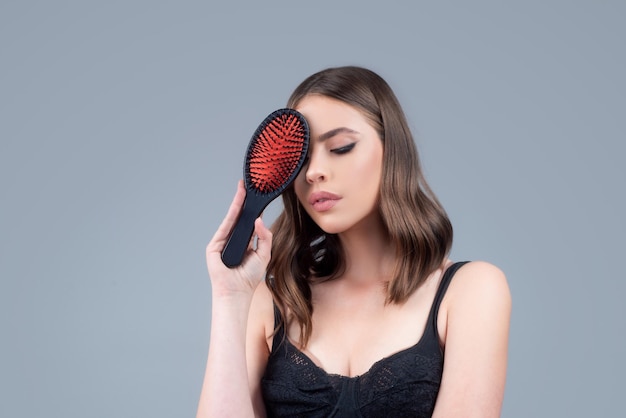 Mujer sonriente cepillarse el cabello con peine hermosa niña con cepillo de pelo largo