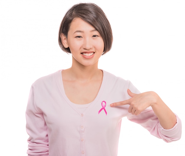 Mujer sonriente con la cinta del rosa de la conciencia del cáncer de pecho.