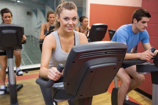 Mujer sonriente en clase de spinning