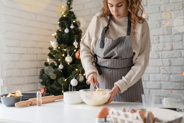 Mujer sonriente en la cocina para hornear galletas de Navidad