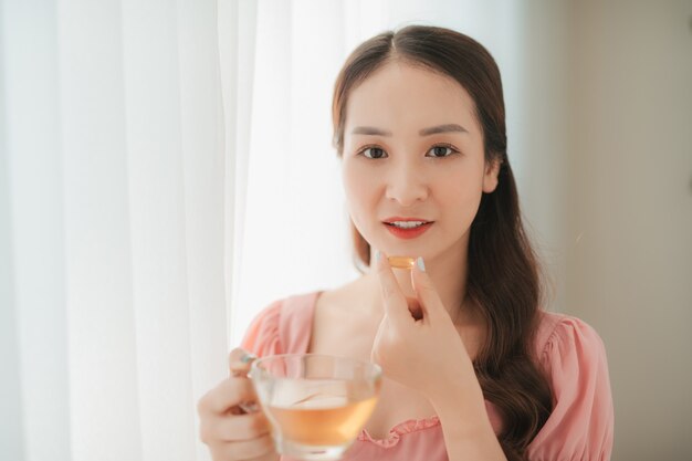 Mujer sonriente comiendo la píldora