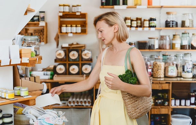 Foto mujer sonriente comprando productos de higiene personal en una tienda de basura cero