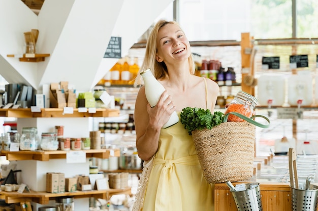 Mujer sonriente comprando productos orgánicos en una tienda de basura cero