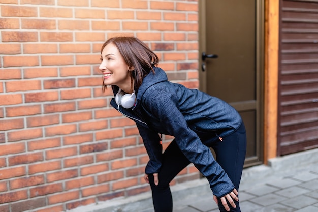 Mujer sonriente descansando después de trotar