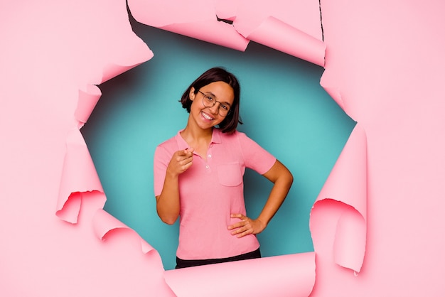 Mujer sonriente detrás de una pared rota