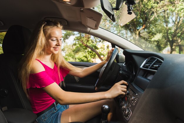 La mujer sonriente enciende el coche con llave